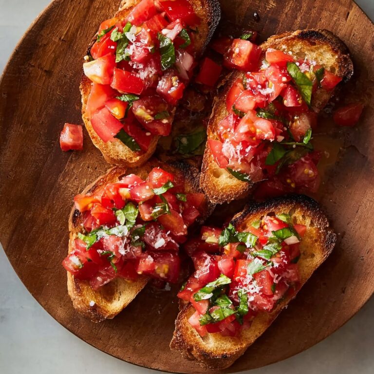 Fresh tomato bruschetta on toasted baguette slices topped with basil, garlic, and olive oil