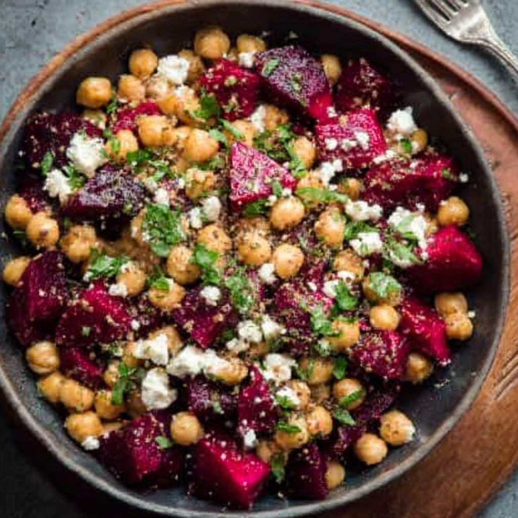 Close-up of chickpea beet salad showing roasted beets, golden chickpeas, creamy feta, walnuts, and lemon dressing