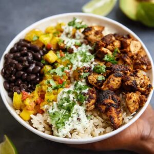 Cuban chicken rice bowl with mojo-marinated chicken thighs over cilantro-lime rice with seasoned black beans, plantains, and avocado