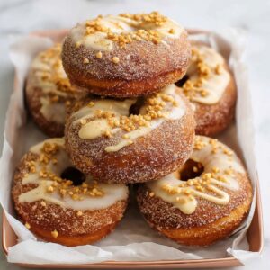 Cinnamon sugar donuts on a wooden plate showing golden baked donuts coated in cinnamon sugar, soft cake-style texture, perfect ring shape